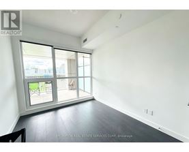 A room with a sliding glass door leading to a balcony.