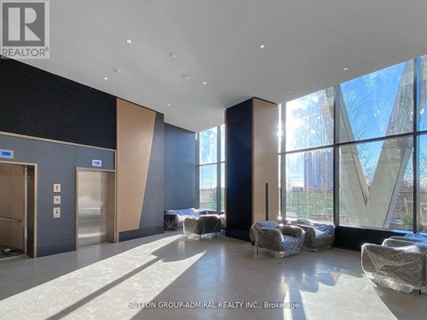 A large, empty room with a lot of windows and a view of a building outside.