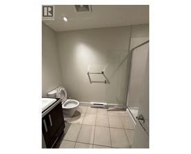 A bathroom with a toilet, sink, and shower.