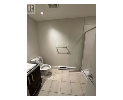 A bathroom with a toilet, sink, and shower.