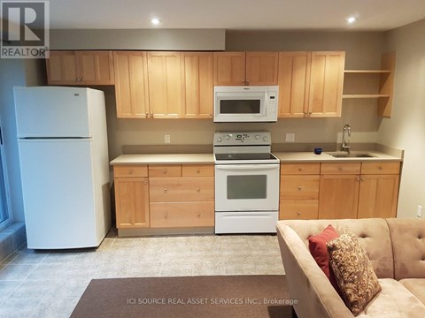 A kitchen with wooden cabinets and a white fridge.