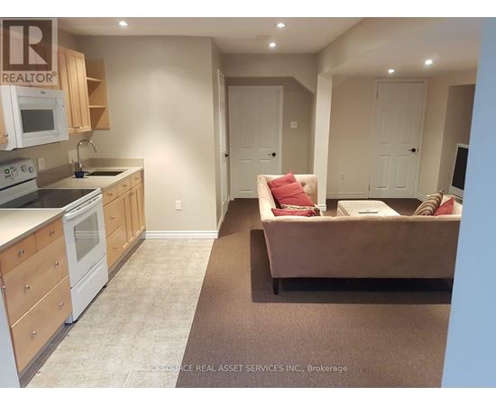 A kitchen with a microwave, oven, and sink.