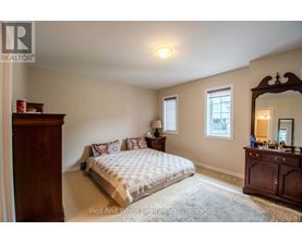 A bedroom with a bed, dresser, and mirror.
