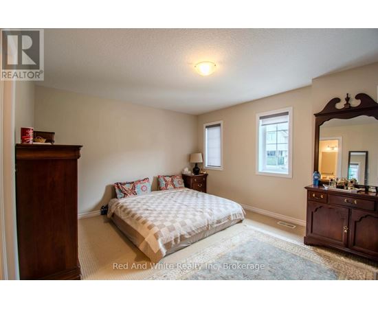 A bedroom with a bed, dresser, and mirror.
