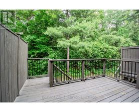 A deck with a railing and trees in the background.