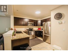 A kitchen with a refrigerator, microwave, and oven.