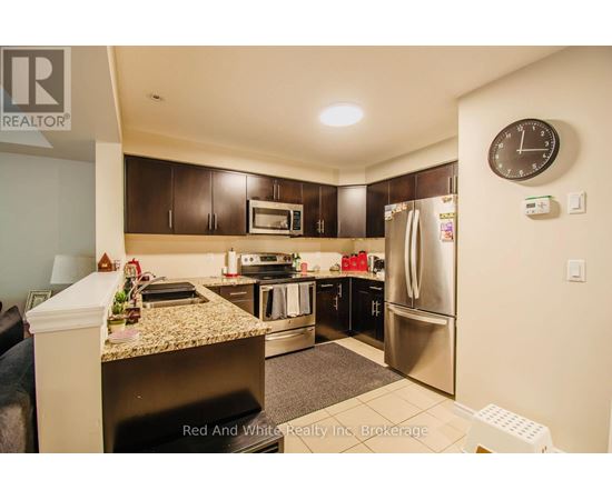 A kitchen with a refrigerator, microwave, and oven.