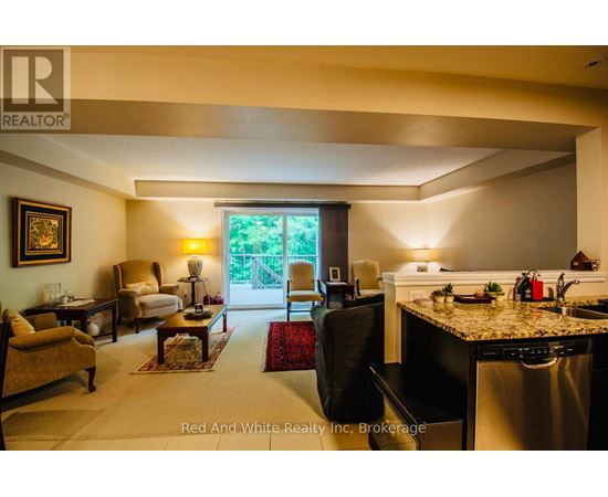 A well-lit kitchen and living room with a dining table and chairs.