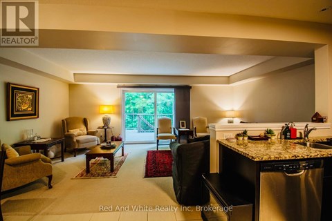 A well-lit kitchen and living room with a dining table and chairs.