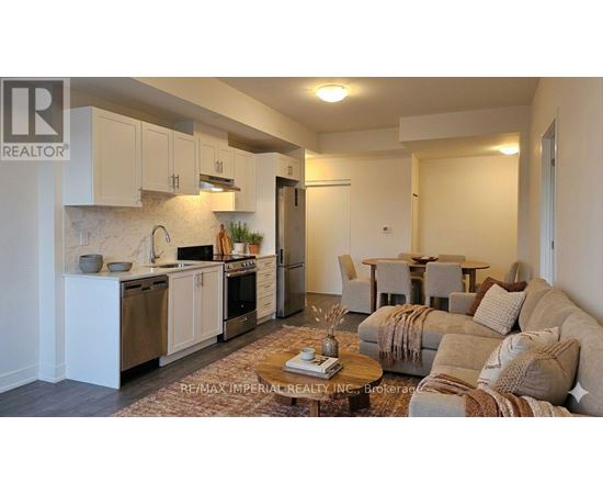 A well-lit, modern kitchen and living room with a sofa and coffee table.