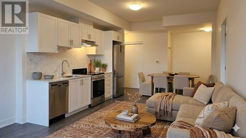 A well-lit, modern kitchen and living room with a sofa and coffee table.