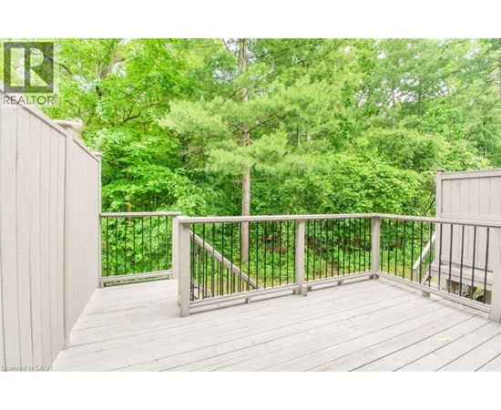 A deck with a railing and trees in the background.