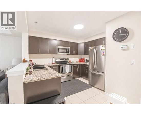 A kitchen with a granite countertop and stainless steel appliances.