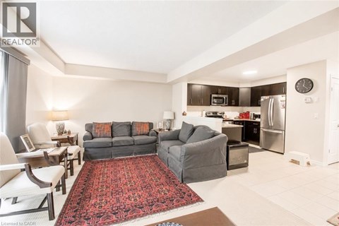 A living room with a grey couch and a red rug.