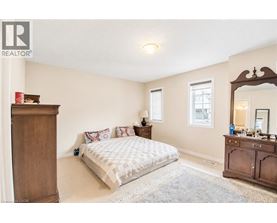 A bedroom with a bed, dresser, and mirror.