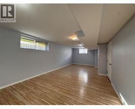 A room with wooden flooring and a window with blinds.