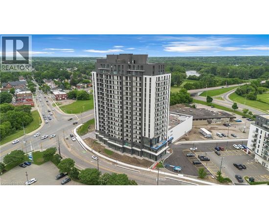 A tall building with a parking lot in front of it.