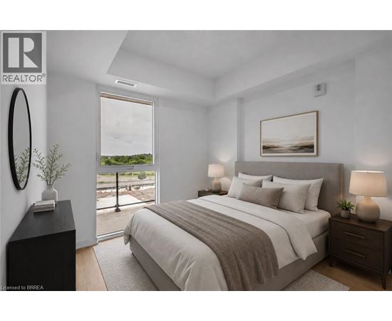 A bedroom with a large bed, a window with a view, and a nightstand with a lamp.