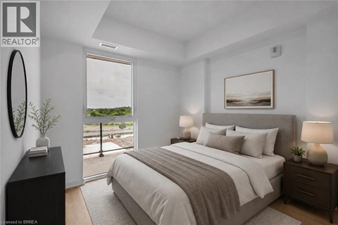 A bedroom with a large bed, a window with a view, and a nightstand with a lamp.
