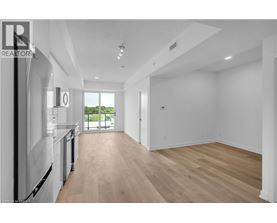 A spacious, empty room with wooden floors and white walls.