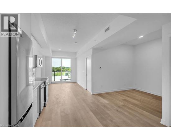 A spacious, empty room with wooden floors and white walls.