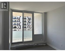 A room with a window showing a building with balconies.