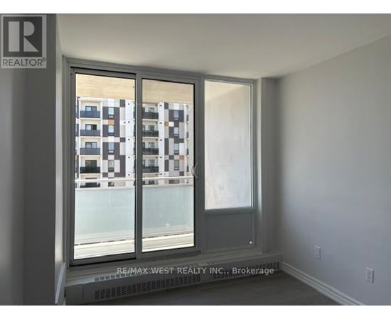 A room with a window showing a building with balconies.