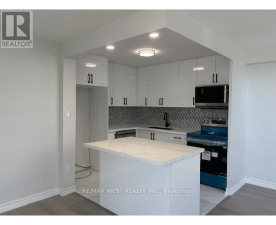 A kitchen with white cabinets and a white island.