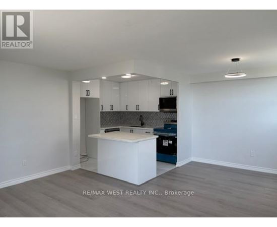 A kitchen with white cabinets and a white island in the middle.