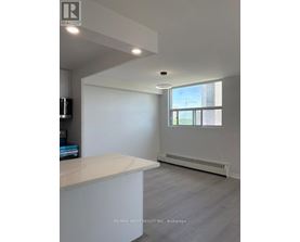 A spacious room with a large window and a white countertop.
