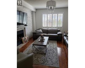 A living room with a grey couch, a coffee table, and a fireplace.