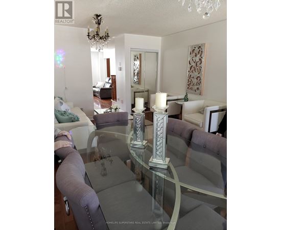 A glass table with a silver candle holder in the middle of it.