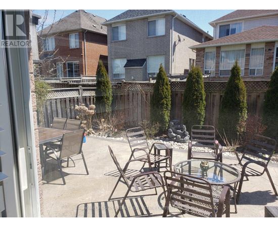 A patio with a table and chairs surrounded by a fence.