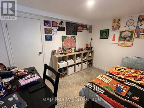 A room with a bed, desk, chair, and shelves filled with items.