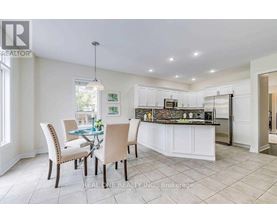 A well-lit kitchen with a dining table and chairs.