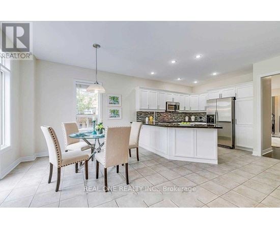 A well-lit kitchen with a dining table and chairs.