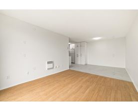 A room with wooden flooring and white walls.
