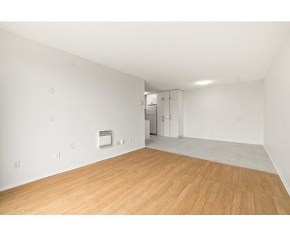A room with wooden flooring and white walls.