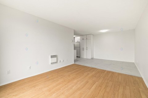A room with wooden flooring and white walls.