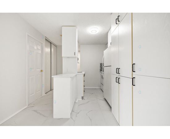 A kitchen with white cabinets and a marble floor.