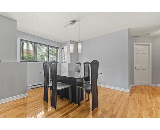 A dining room with a table and chairs.