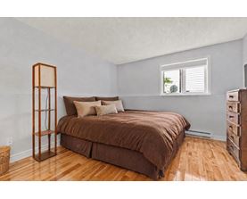 A bedroom with a brown bed and wooden floors.
