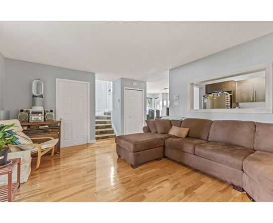 A living room with a brown couch and a wooden floor.