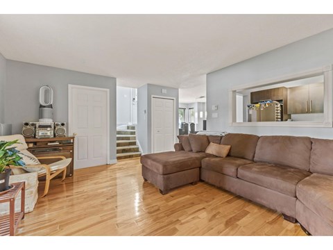 A living room with a brown couch and a wooden floor.