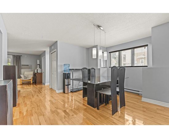 A kitchen with a dining table and chairs.