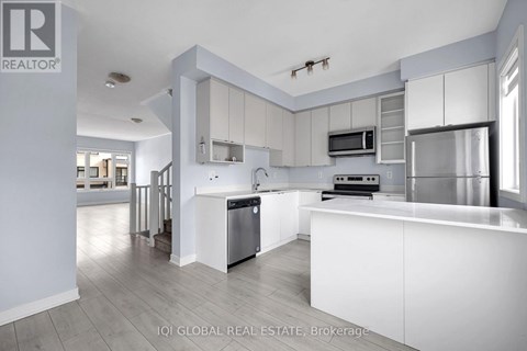 A modern kitchen with white cabinets and stainless steel appliances.