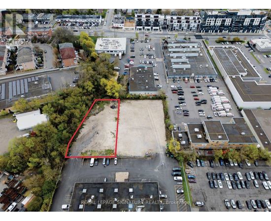 An aerial view of a parking lot with a red outline indicating a property for sale.