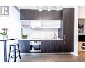 A modern kitchen with dark wood cabinets and stainless steel appliances.