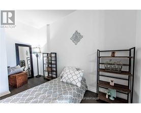 A bedroom with a bed, shelves, and a mirror.