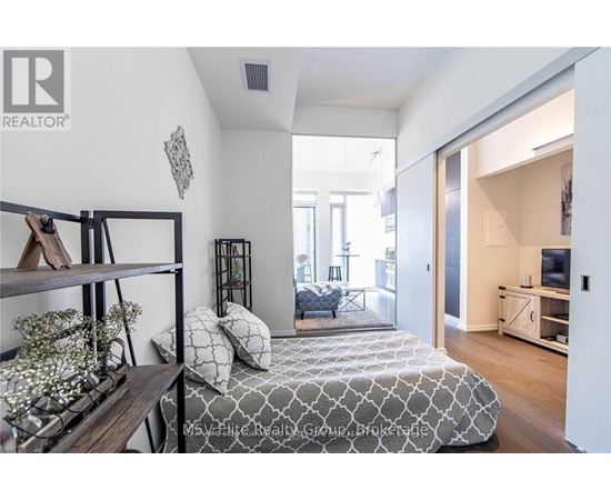 A bedroom with a bed, a shelf, and a window.